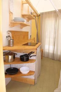 cocina con encimera con ollas y sartenes en Campeggio Europa en Torre del Lago Puccini