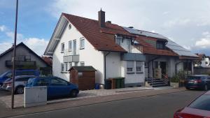 une maison blanche avec un toit rouge dans une rue dans l'établissement Ferienwohnung Sandra Hockenheim, à Hockenheim