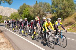 a group of people riding bikes down a road at Cala Millor Garden Hotel - Adults Only in Cala Millor