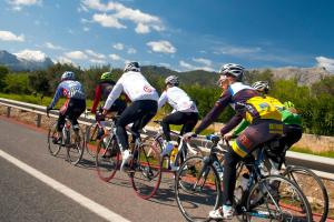 a group of people riding bikes down a road at Cala Millor Garden Hotel - Adults Only in Cala Millor
