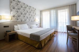 a hotel room with a large bed and a desk at Hotel SPA TermaEuropa Balneario Arnedillo in Arnedillo +36 photos