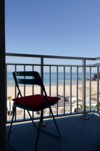 a chair sitting on top of a balcony with the beach at La Finestra sul Castello B&B in Termoli