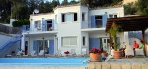 a house with a swimming pool in front of it at Villa Daphne in Pelekas