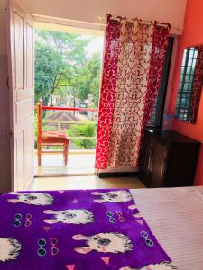 a bedroom with a bed and a large window at Eden Homestay Alleppey in Alleppey