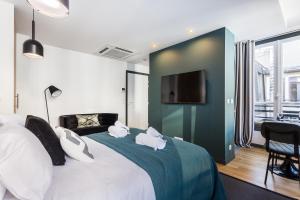 1 dormitorio con 1 cama grande y 2 toallas. en CMG Champs Elysées - Boetie 4DD, en París