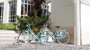 drie fietsen geparkeerd buiten een huis bij Albergaria Sao Pedro in São Martinho do Porto