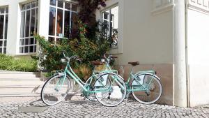 three bikes parked outside of a house at Albergaria Sao Pedro in São Martinho do Porto