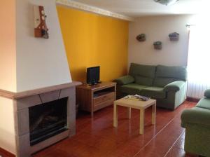 a living room with a couch and a fireplace at Casa Rural La Alegría de la Alcarria III in Torremocha del Campo