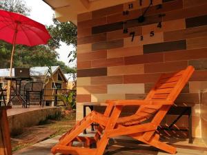 una sedia in legno seduta accanto a un tavolo con ombrellone di Lungphut Homestay a Chiang Mai