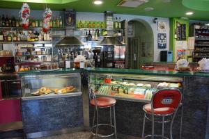 a restaurant with two bar stools and a counter with food at Albano Station Rooms in Pavona