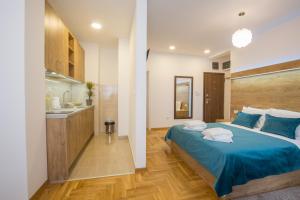sypialnia z niebieskim łóżkiem i kuchnią w obiekcie Thomas Residence w Belgradzie
