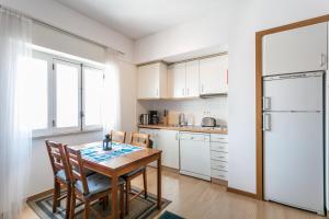 La cuisine est équipée d'une table, de chaises et d'un réfrigérateur. dans l'établissement FLH Principe Real Cozy Flats, à Lisbonne