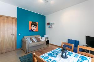 - un salon avec un canapé et un mur bleu dans l'établissement FLH Principe Real Cozy Flats, à Lisbonne