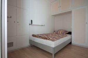 ein kleines Schlafzimmer mit einem Bett und weißen Schränken in der Unterkunft Ferienwohnung Doris Seitz in Schweinfurt