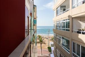 a view of the beach from the balcony of a building at RK Atlantis Vacational in Las Palmas de Gran Canaria