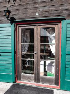 eine Tür zu einem Gebäude mit Grün und Holz in der Unterkunft Weigl Hütte Semmering in Semmering