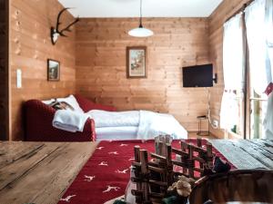 ein Wohnzimmer mit einem Bett und einem Tisch mit Stühlen in der Unterkunft Weigl Hütte Semmering in Semmering