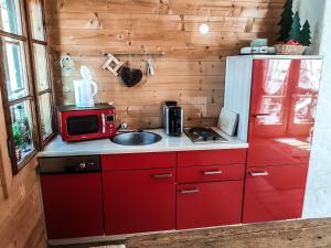 una cucina con forno a microonde e frigorifero rosso di Weigl Hütte Semmering a Semmering Altre 37 foto