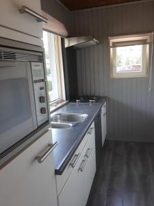 a small kitchen with a sink and a microwave at Ardennen Bungalow Belle Vue - Bomal - Durbuy in Durbuy