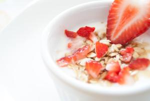 a bowl of cereal with a strawberry on top at The Barnyard in Balinge