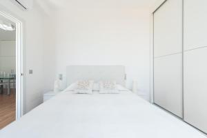 1 dormitorio blanco con 1 cama blanca grande y 2 almohadas en Lovely balcony sea views By CanariasGetaway en Las Palmas de Gran Canaria
