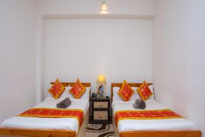 two beds in a room with white walls at The Boudha Inn in Kathmandu