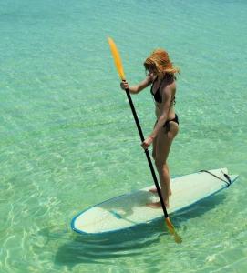 Eine Frau im Bikini auf einem Surfbrett im Wasser. in der Unterkunft Ocean Tally in Upper Bogue