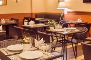 restauracja ze stołami i krzesłami z talerzami i kwiatami w obiekcie Le Vashoff Hotel w Petersburgu