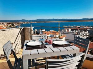 a table on a balcony with a view of the water at Ático 3M Sanxenxo in Sanxenxo