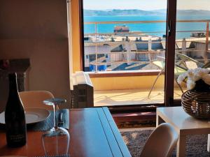 a table with a bottle of wine and a view of a balcony at Ático 3M Sanxenxo in Sanxenxo