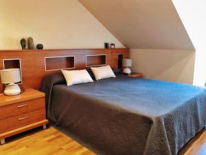 a bedroom with a large bed and two lamps at Ático 3M Sanxenxo in Sanxenxo