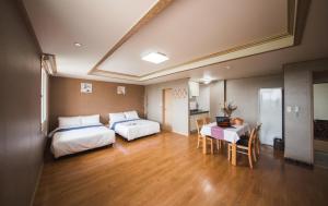 a hotel room with two beds and a table and a dining room at Jungmun Resort Jeju in Seogwipo