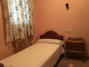 a small bedroom with a bed and a window at Hostal Moraleda ** in Piedrabuena