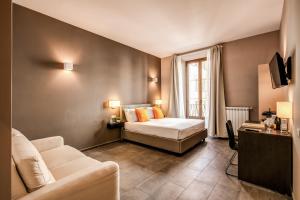 ローマにあるH501 Luxury Roomsのベッドとソファ付きのホテルルーム