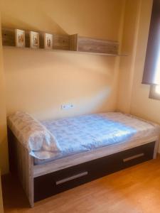 a small bedroom with a bed with blue sheets at Apartament Vall d'Àger II in Ager