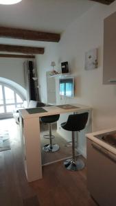 uma cozinha com uma secretária e 2 bancos de bar em Sam Le Lezard Sarl em Nice