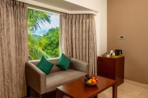 Una sala de estar con un sofá y una ventana grande. en Mango Suites Viera, en Hyderabad