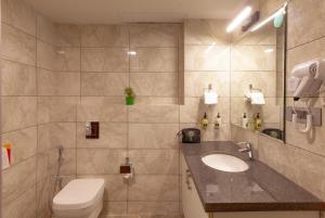 un baño con inodoro y lavabo en Mango Suites Viera, en Hyderabad 26 fotos más