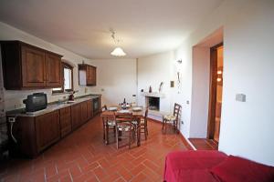 una cucina con tavolo e sedie in una stanza di Agriturismo Bellavista apt La Pergola a Castagneto Carducci