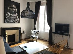 a living room with a couch and a fireplace at Appartement Lanjuinais in Rennes