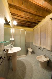 a bathroom with two sinks and a toilet at Antico Borgo Poggiarello in Monteriggioni