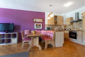 a kitchen with a table and a purple wall at Couples Getaway in Bohinj