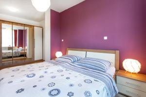 a bedroom with a large bed with purple walls at Couples Getaway in Bohinj +10 photos