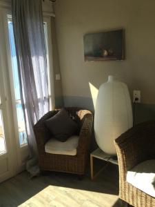 uma sala de estar com uma cadeira e um vaso ao lado de uma janela em 40 Rue du Ventoux em Bédoin