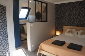 1 dormitorio con 1 cama con 2 toallas negras en L'écrin de l'Océan, 80 mètres de la mer., en Le Pouliguen