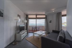 un salon avec un canapé et une table dans l'établissement Vista Dorada al mar balcón-Wifi By CanariasGetaway, à Las Palmas de Gran Canaria