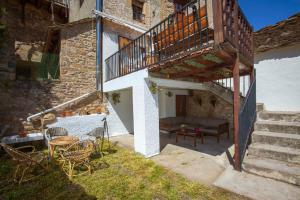 a patio with a table and chairs and a staircase at CASA SENERA in Santa Cruz de la Serós
