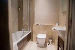a bathroom with a tub and a toilet and a sink at Hotel Rue in Omagh