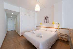 1 dormitorio blanco con 1 cama blanca grande y 2 almohadas en Yellow Sun Marine I By CanariasGetaway, en Las Palmas de Gran Canaria