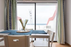 comedor con mesa, sillas y ventana en Yellow Sun Marine I By CanariasGetaway, en Las Palmas de Gran Canaria